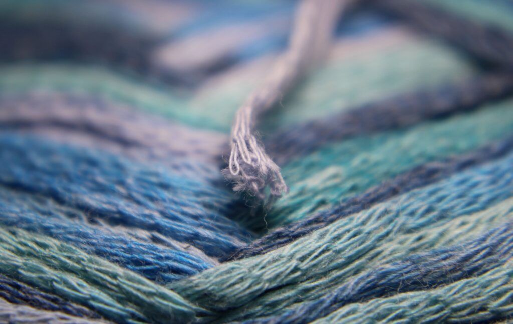 A thread of yarn, signifying the weaving of a masterful story for marketing